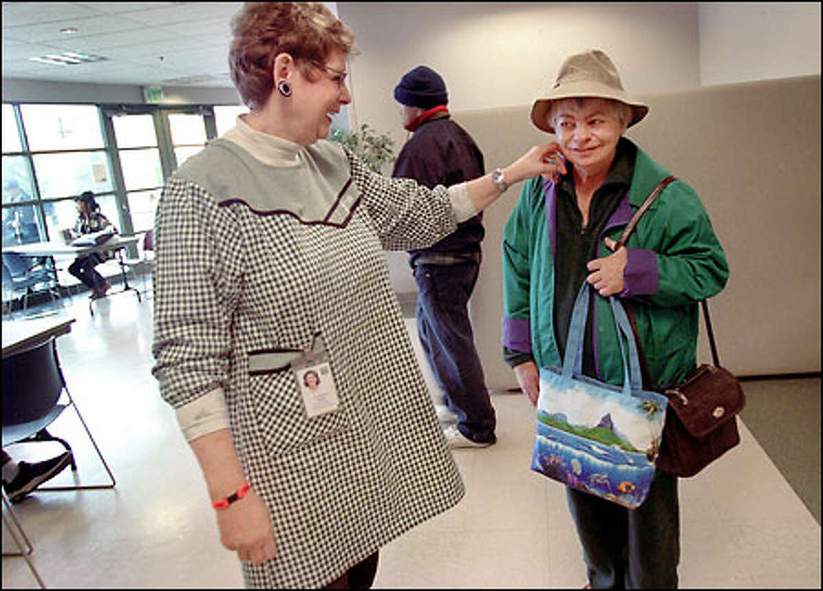 Bird, left, strokes the cheek of her friend Judy Thompson during a break from her job at the Greater Lakes Mental Health Foundation in Lakewood. "She is a good friend," says Thompson of Bird. "She cuts my hair and sometimes has me over to her apartment."