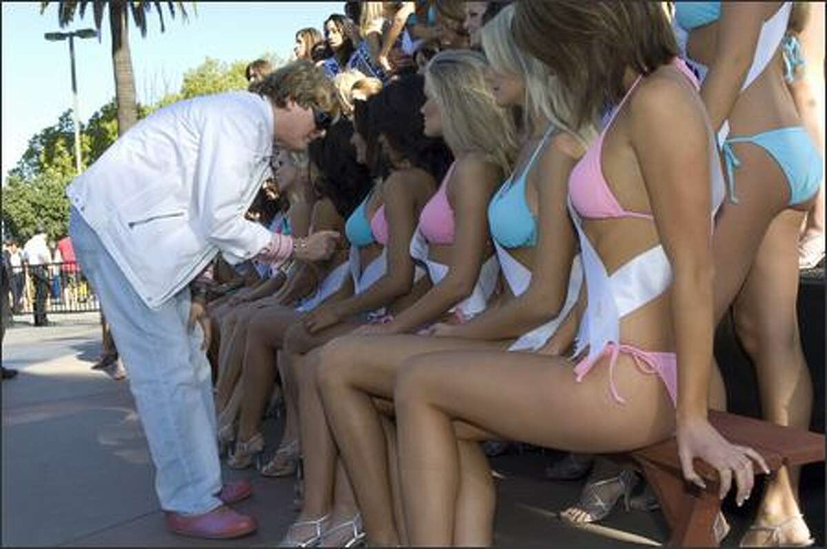 Wardrobe assistant David Profeta helps contestants for the 2007 Miss USA competition with their swimwear by BSC Thailand and Nina shoes prior to a poster shoot at Universal Studios on March 12.