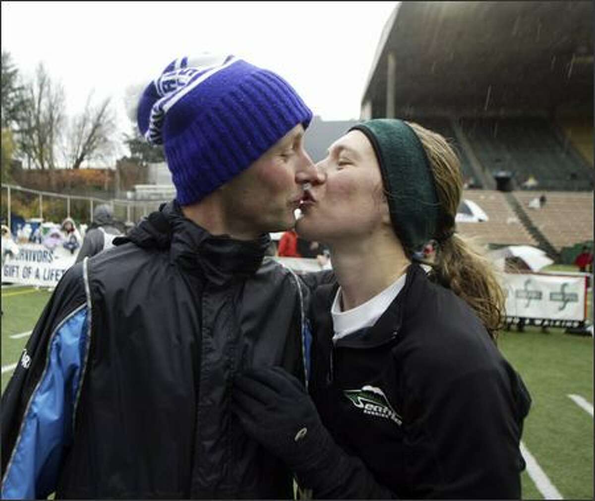 Uli Steidl, 34, and Trisha Steidl, 29, share a kiss after becoming the first married couple to sweep the men's and women's races in the Seattle Marathon. Uli scored his eighth win with a time of 2:25:54, while Trisha placed first with a time of 3:01:36.