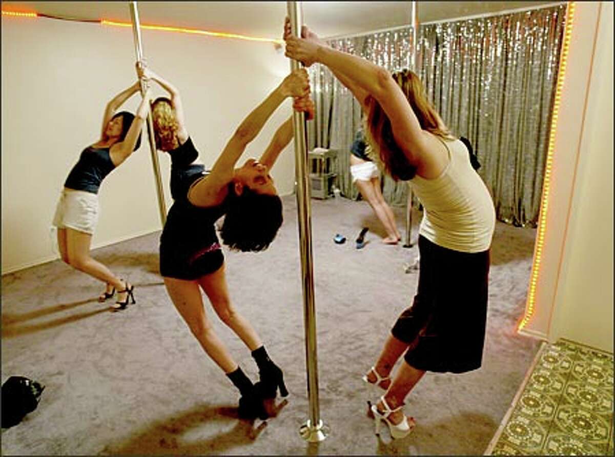 Krisha CatZen, center front, leads her pole-dancing class in stretching exercises. The former go-go dancer says, "This is about raising self-esteem, fitness and building strength in your arms and abs."Schenker: I included this photo because how often do you get to photograph a pole dancing class?