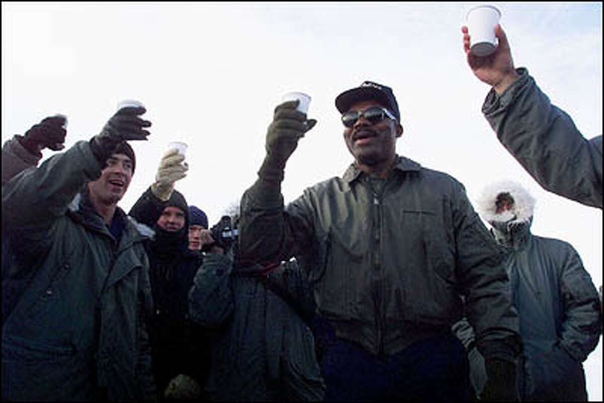 In nautical tradition, the oldest and youngest member of the Polar Star crew rang a bell and gave a toast for the New Year. On the left are Seaman apprentice Douglass Adams, 17, the youngest (toasting with Pepsi), and Master Chief James Parks, 49. At the time it was approximately -14 degrees with the wind chill factor.
