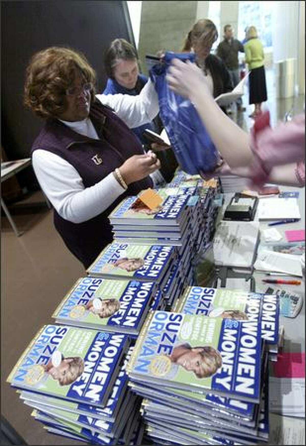 Tanya Jimale buys four copies of Suze Orman's book, Women & Money, for herself, an office mate and friends, prior to a speech and book signing by the finance expert at the downtown branch of the Seattle Public Library Monday.