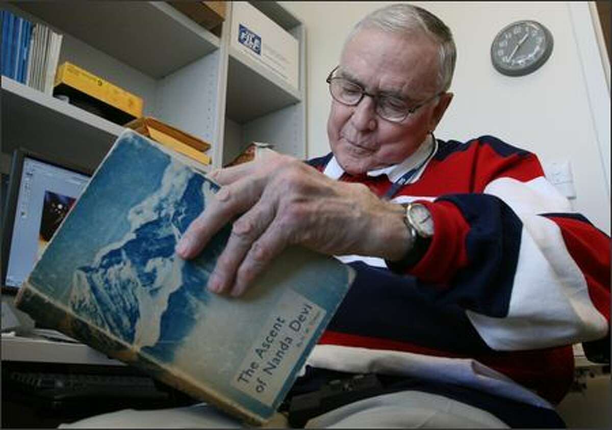 Robert Schaller, a former pediatric surgeon who still teaches at Children's Hospital and Regional Medical Center in Seattle, looks over a copy of "The Ascent of Nanda Devi." In 1965, Schaller tried to scale the peak to install a listening device that never made it to the top.