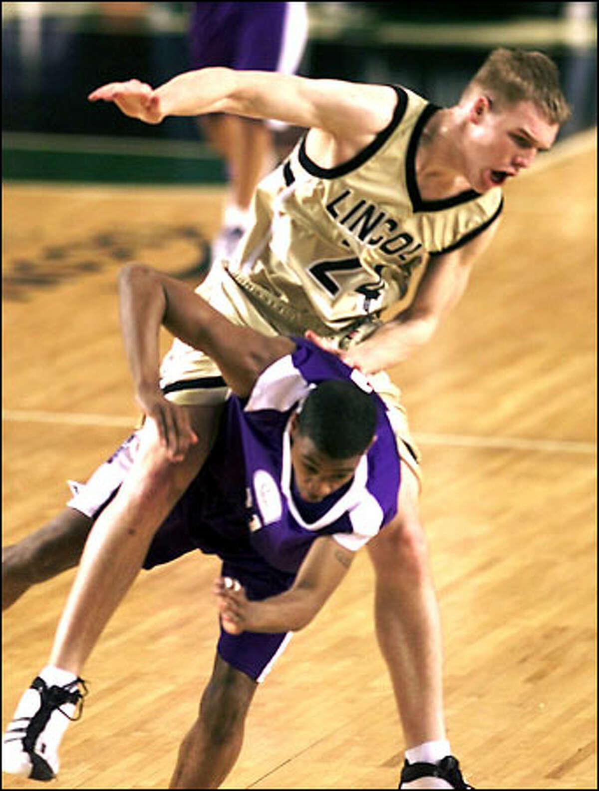 Lincoln's Ben Shelton ends up on top of Garfield's Quinnan Braxton as the pair raced for a errant pass during their playoff game at the Tacoma Dome Thursday March 8, 2002.