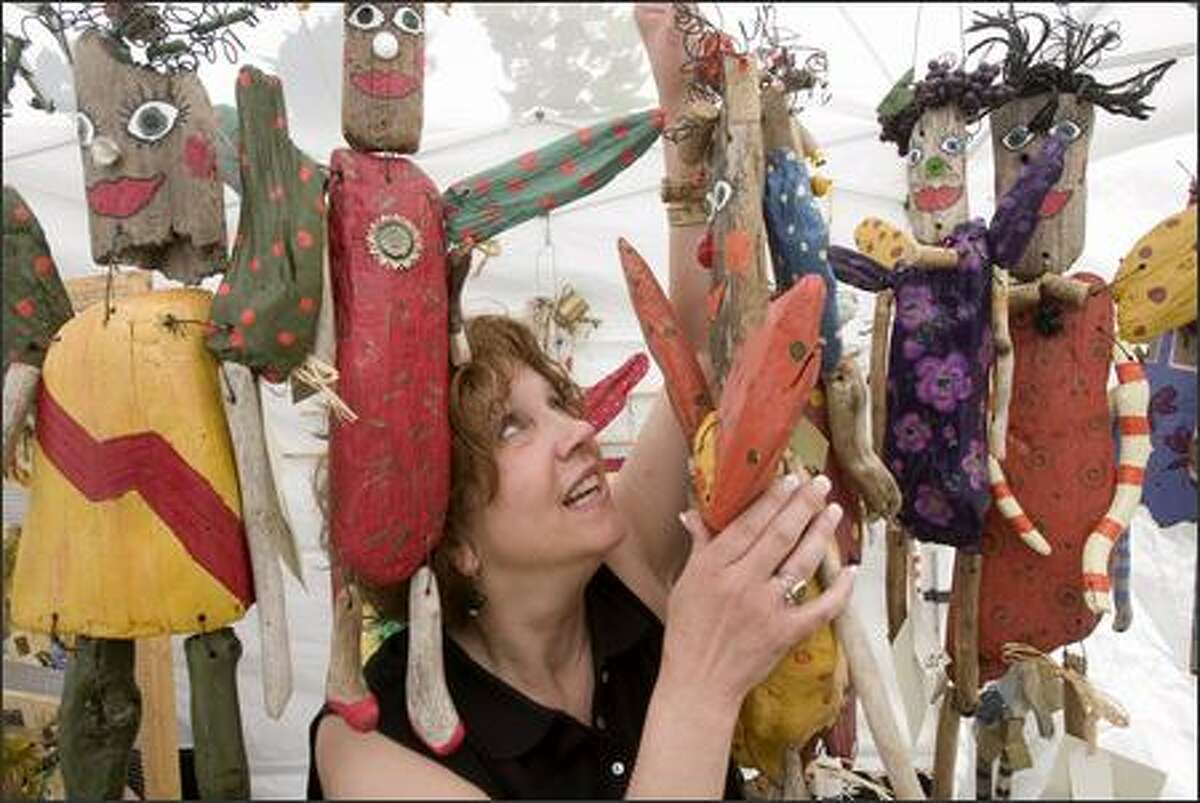 Lettie Haggard adjusts some of the "garden angels" she was selling in a booth at the Solstice celebration Saturday in Fremont.