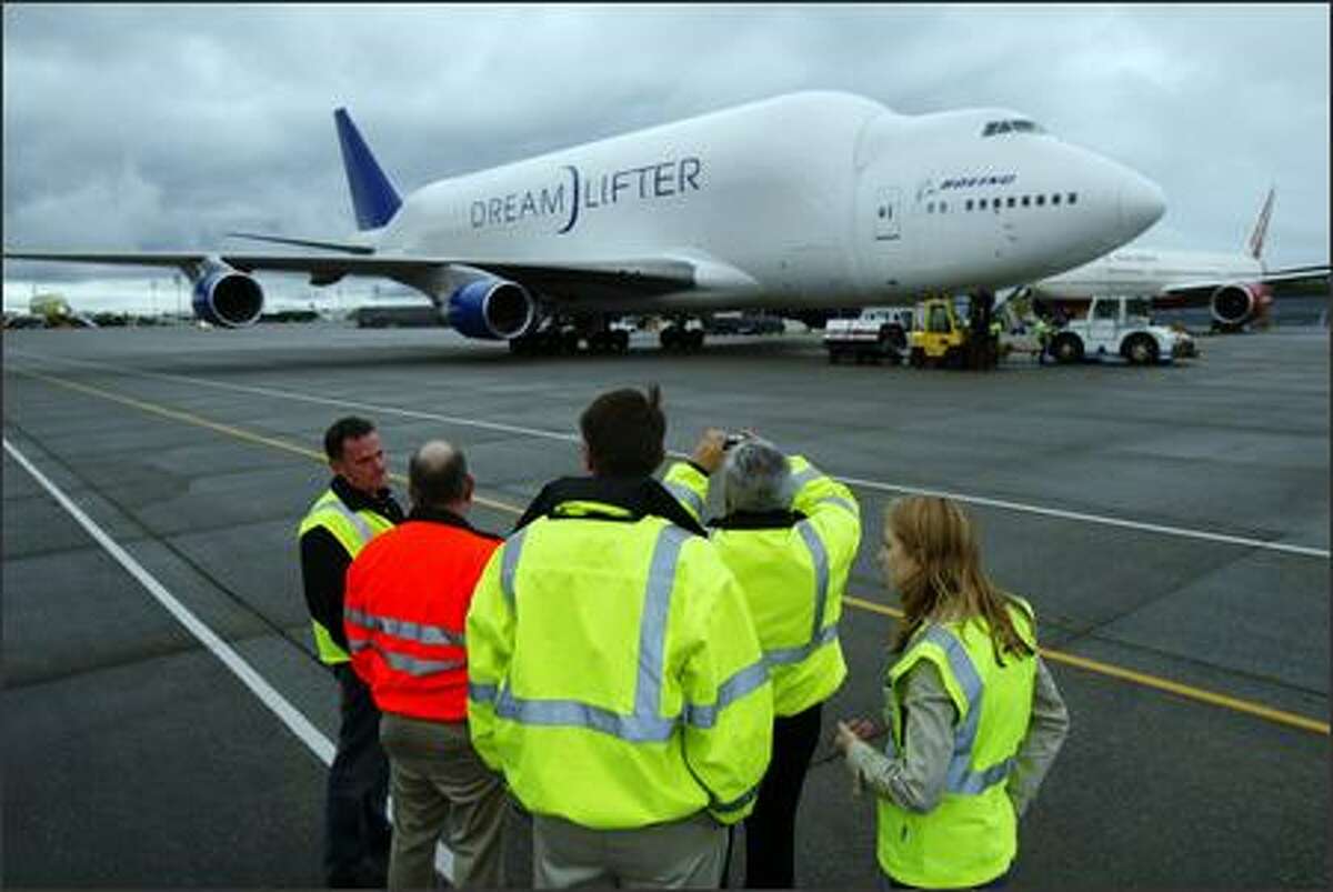 A modified 747, the Dreamlifter, is worked on by crew after landing.