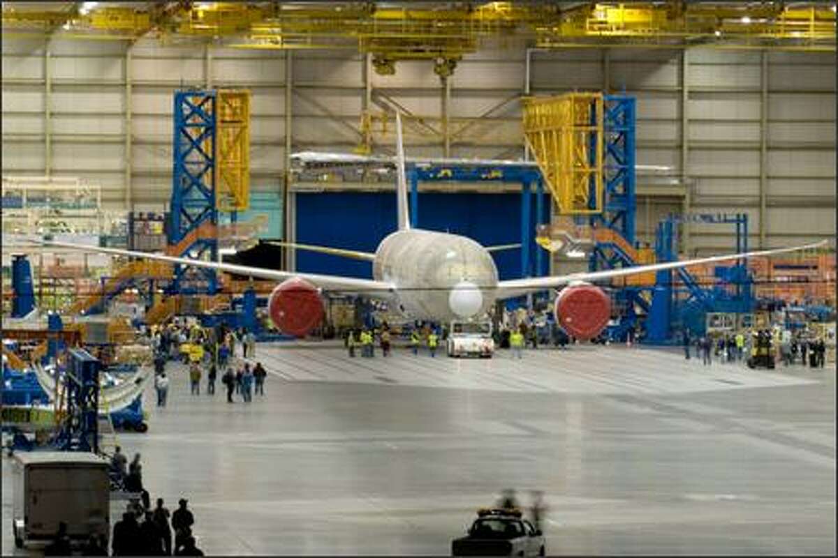 The first 787 Dreamliner sits inside the assembly bay in Everett after the doors were opened around midnight Tuesday, before being rolled outside and moved to a paint facility. Aviation enthusiast and pilot Charles Conklin of Kirkland had picked up hints about the unofficial rollout on an aviation Web site and had waited outside the perimeter of the Boeing property since shortly after 10 p.m. Monday. This was his payoff. (Photo by Charles Conklin)