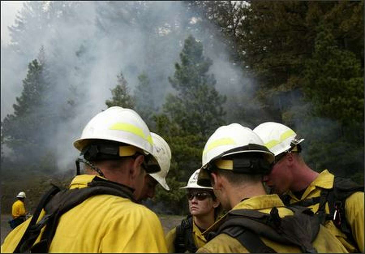 A fire crew from the Naches Ranger District discusses the plan as they begin a controlled burn in the Okanagan-Wenatchee National Forest near Naches on Friday May 18, 2007. The burn was to thin dense ground cover to prevent future wild fires as part of a forest management plan.