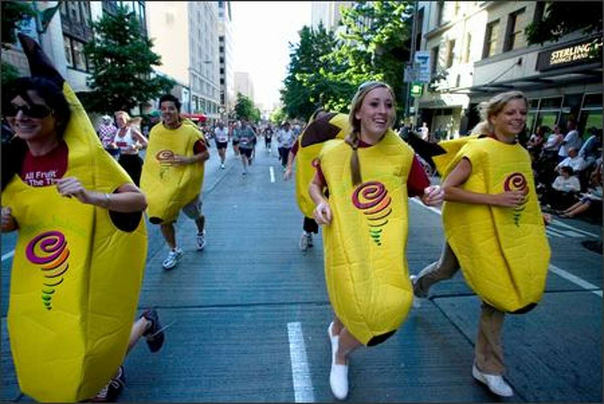 A group of runners dressed in banana suits promoting the Jamba Juice chain takes part in the Torchlight Run at the 58th annual Seafair Torchlight Parade.