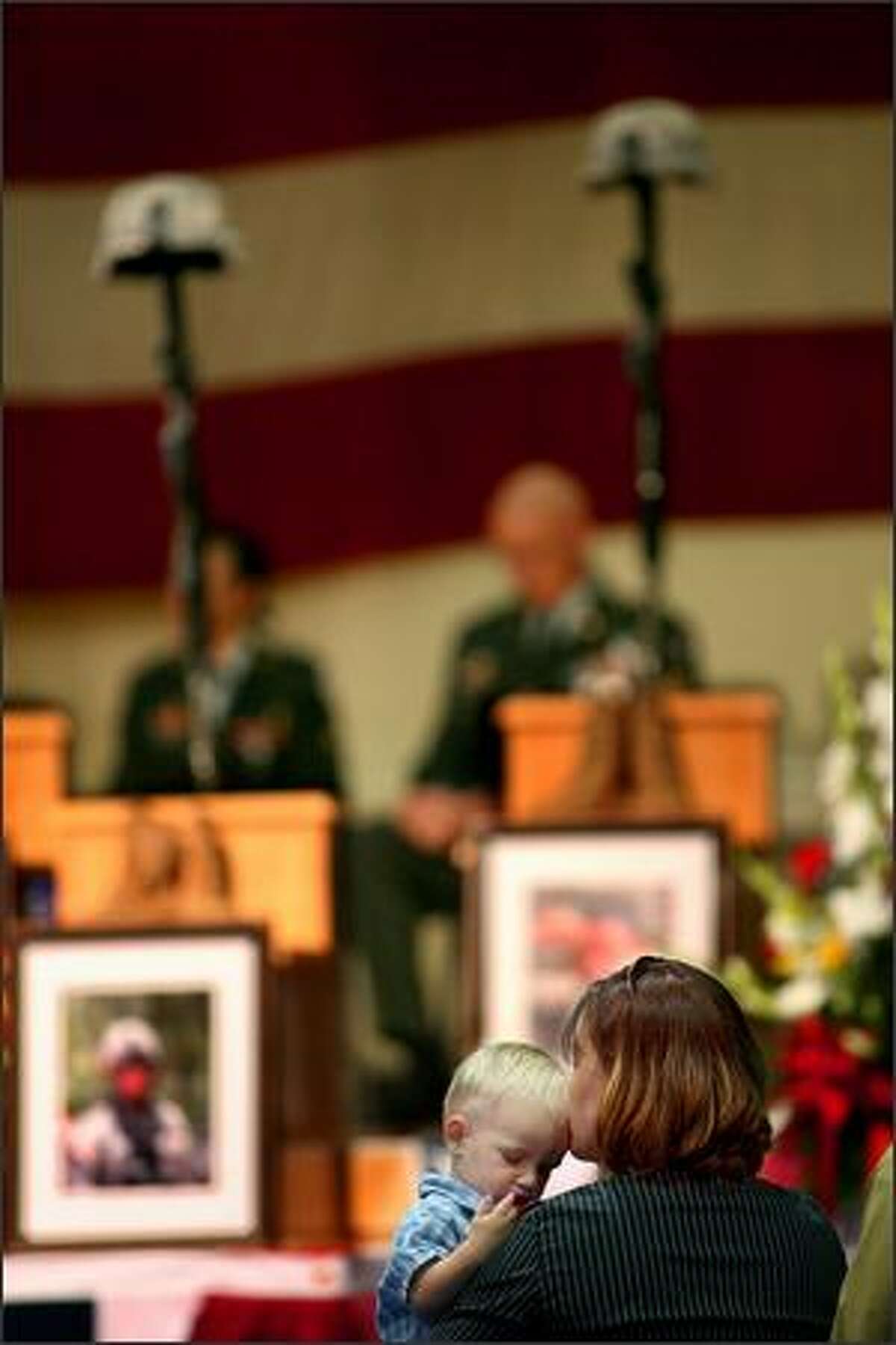 Brenda Long kisses her son Sage at the memorial for her husband and Sage's father SSG Brian Long on Thursday.