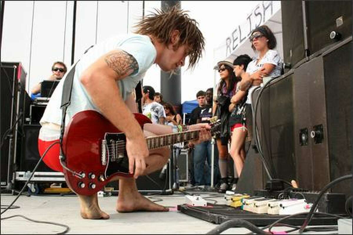 Jason Hale of Chiodos tests his effects pedals between songs at the Warped Tour on Saturday.