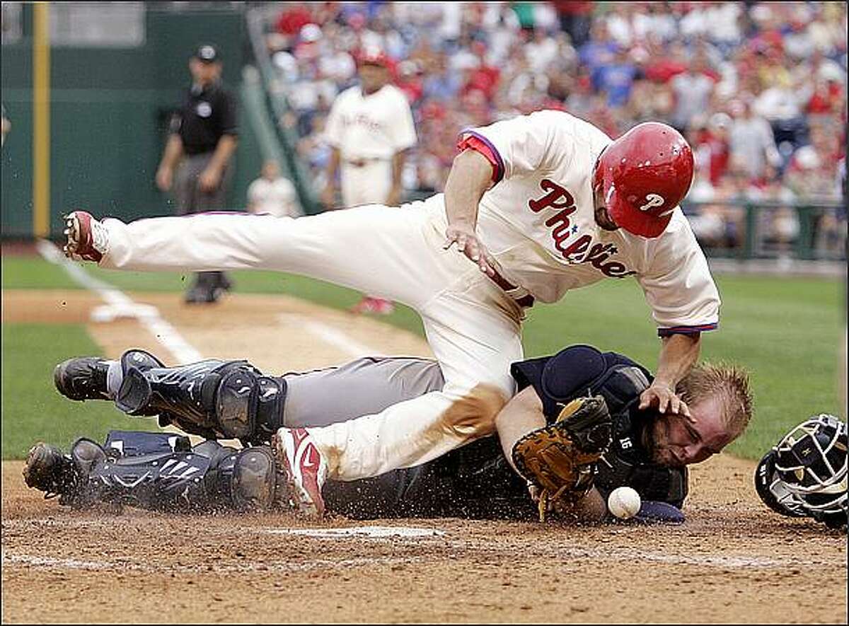 Philadelphia Phillies' Shane Victorino, top, collides with Atlanta Braves' Brian McCann as he scores on Ryan Howard's two-run single in the sixth inning of a baseball game in Philadelphia. McCann was injured and left the game. (AP Photo/Tom Mihalek)wbb