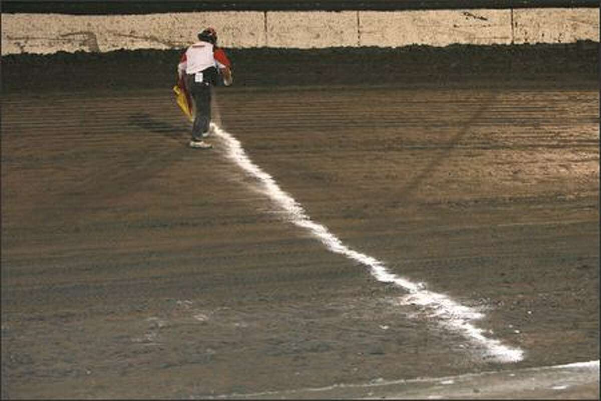 Chip Pelton sets the start line in chalk Wednesday night at Skagit Speedway.