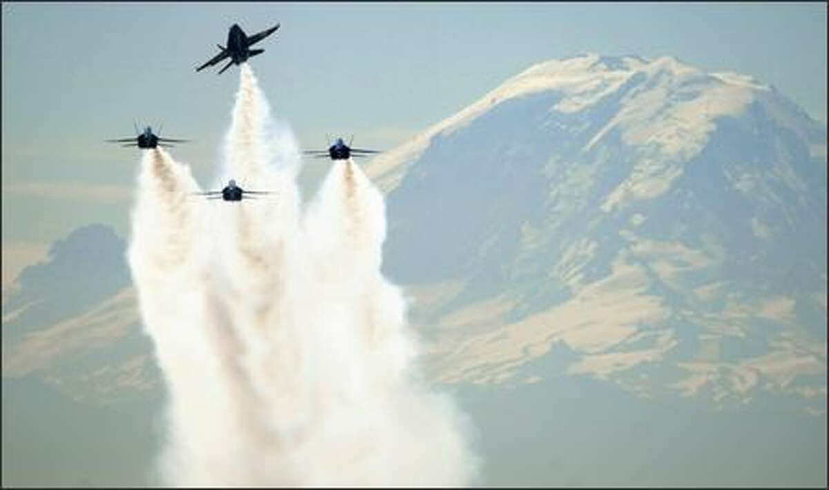 The Blue Angels leave a smoke trail as they pass in front of Mount Rainier during practice on Thursday. The U.S. Navy acrobatics team is preparing for its annual performance at Seafair this Sunday.