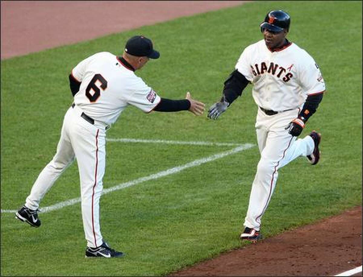 Barry Bonds #25 of the San Francisco Giants is congratulated by Tim Flannery #6 as he rounds the bases after hitting career home run number 754 during the first inning against the Florida Marlins at AT&T Park July 27, 2007 in San Francisco, California. Photo by Justin Sullivan/Getty Images