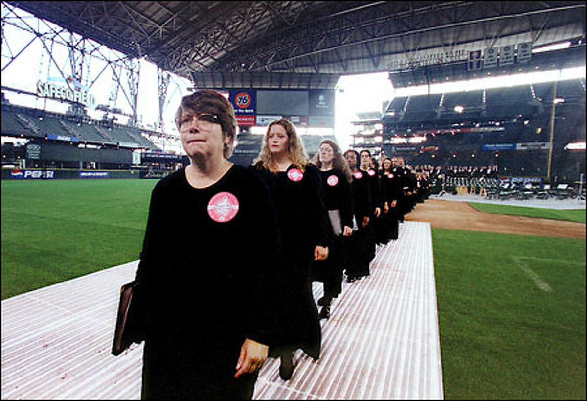Members of Seattle Symphony Chorale file off the diamond at Safeco Field after performing in the Emerald City's installment of the Rolling Requiem, in which some 180 groups from 26 countries performed Mozart's Requiem in commemoration of the events of Sept. 11, 2001.