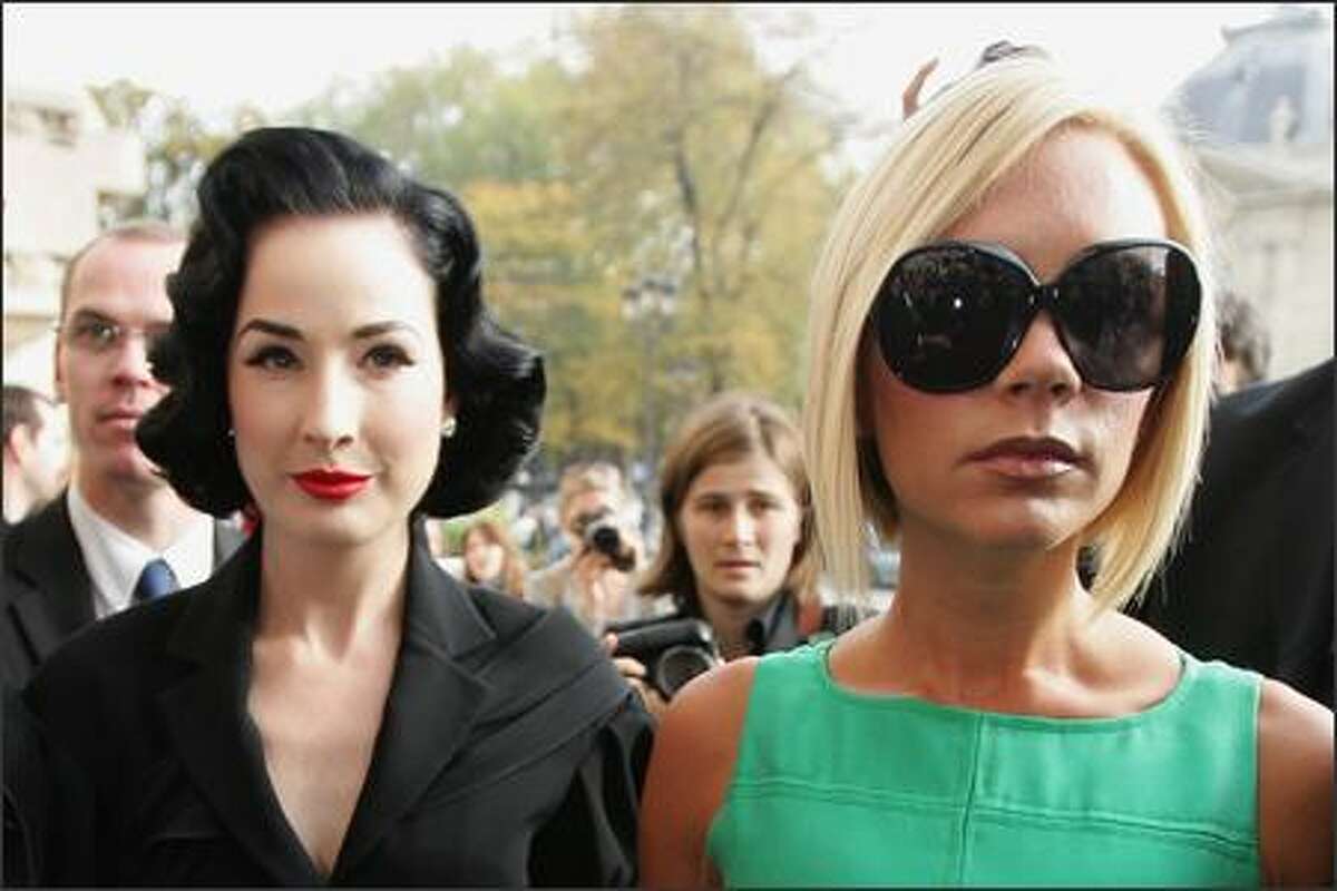 Singer Victoria Beckham (R) and burlesque artist Dita Von Teese (L) arrive to attend the Chanel Fashion show during the Paris Fashion Week Sp/Sum October 5, 2007 in Paris, France.