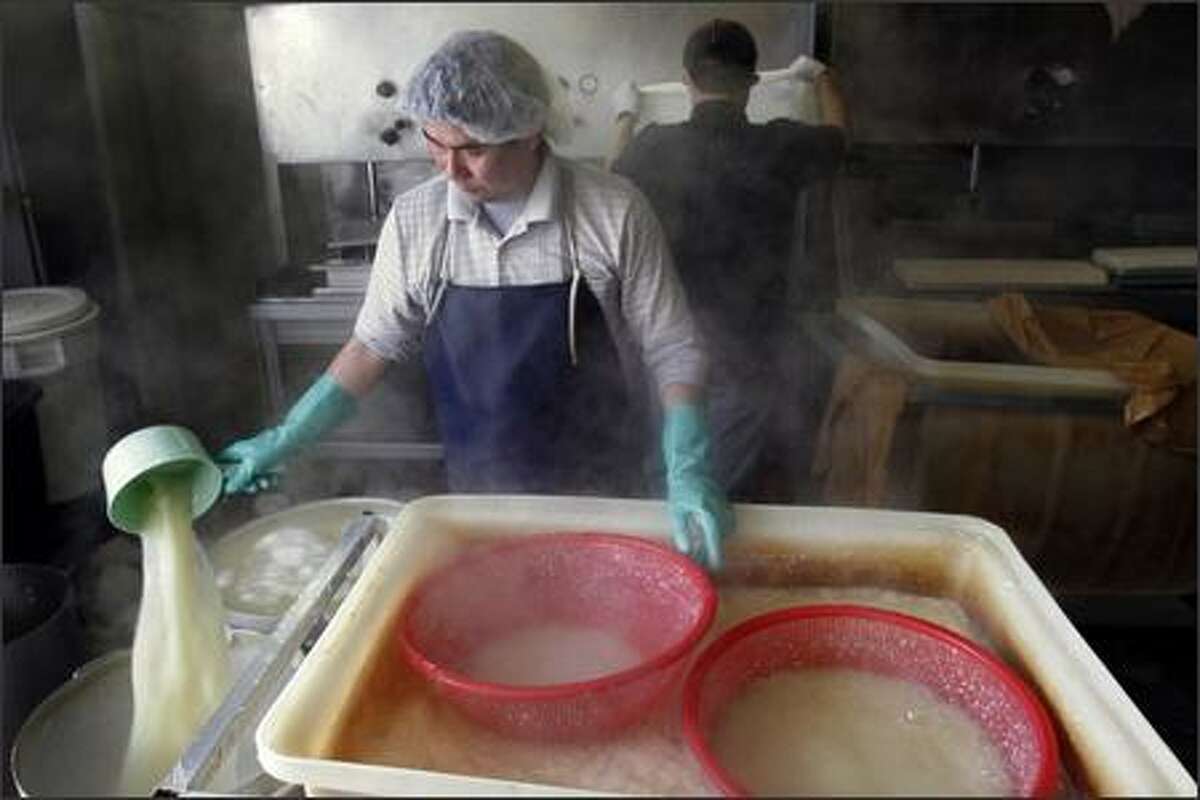 Luong Ho removes the whey from the coagulant (soybean curd) before it is placed into molds and pressed.