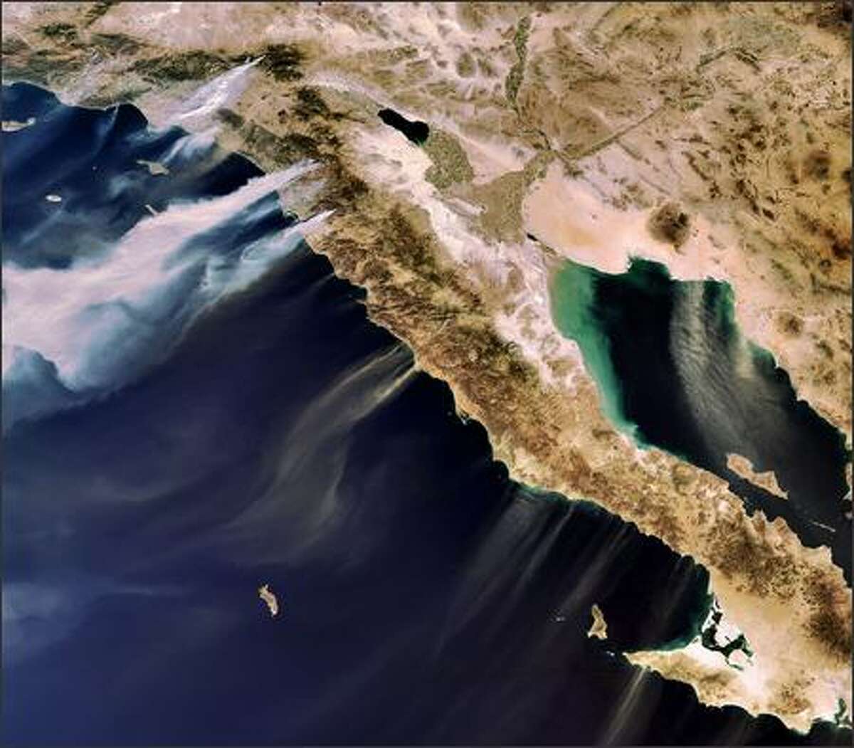 A photo provided by the European Space Agency ESA shows the Envisat's MERIS image, acquired on Oct. 22, 2007, of desert winds blowing smoke from wildfires in Southern California. Sand is visible being blown from Mexicos Baja California Peninsula over the Gulf of California to the east and the Pacific Ocean to the west.