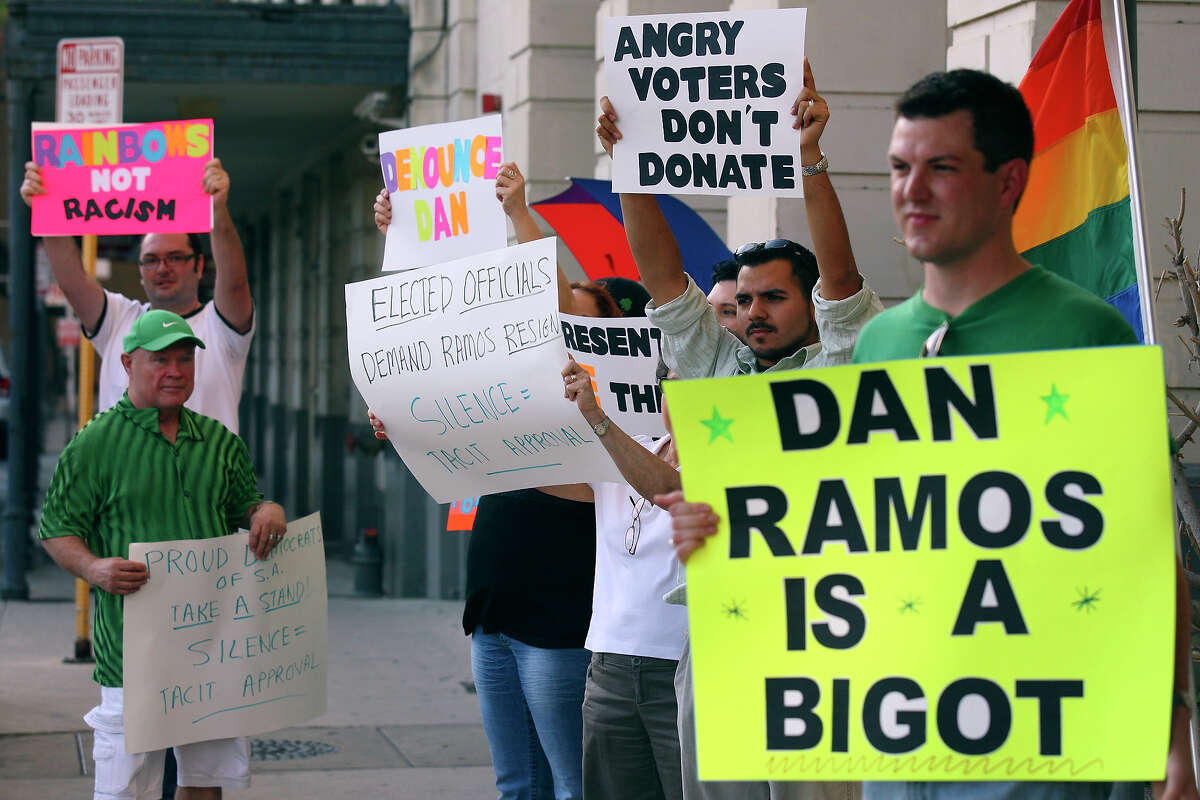 People protest against county Democratic Chairman Dan Ramos outside a party function at Granada Homes.