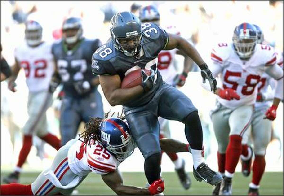 Seattle Seahawks fullback Mack Strong makes 14 yards before being brought down by New York Giants R.W. McQuarters at Qwest Field on Saturday, Sept. 23, 2006. (Mike Urban/Seattle Post-Intelligencer)