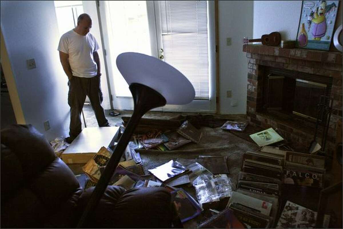 Charlie Divine looks at 25 years worth of record albums that were destroyed by flooding in his apartment Monday at the Jackson Greens Apartments at 15th Ave. NE and NE 135th St. in Seattle. This was the first chance Devine had to return and assess the damage after being evacuated at 4:00am Monday, and spending the night in a motel. He had just moved his belongings into the new apartment on Friday of last week. In addition to the record collection, a brand new computer, new recliner, new desk and new shelving were all drowned.