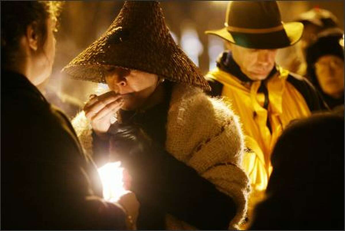 Mary Lou Salter lights sage during a vigil Wednesday near where Davina Garrison, who was homeless, was killed on Thanksgiving Day under the Alaskan Way Viaduct.