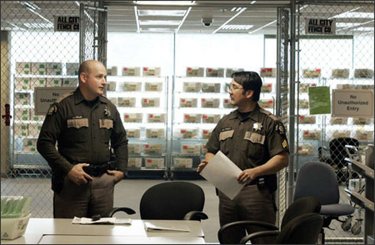 King County Sheriff's Deputies J.J. Keller, left, and J.K. Pewitt guard election ballots at a processing center in Tukwila last November. Pewitt, a sergeant on the sheriff's SWAT team, is one of the highest-paid employees in King County because of his overtime accrual.