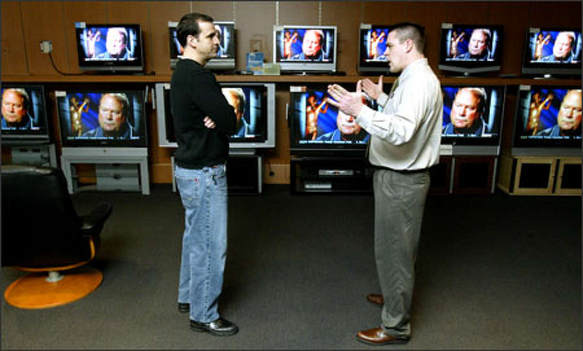 Magnolia Audio Video's Ted Wendt, right, explains the differences among big-screen televisions to customer Robert Todd at the company's Roosevelt store Tuesday.