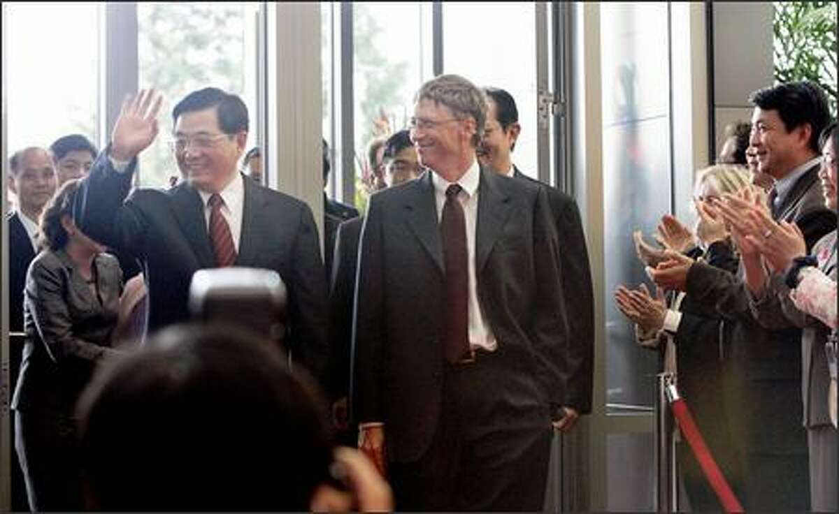 Chinese President Hu Jintao arrives at Microsoft headquarters with Chairman Bill Gates as Microsoft employees applaud in Redmond on Tuesday.