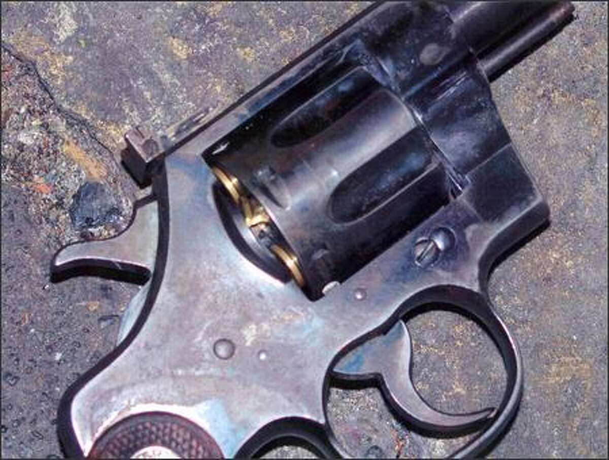 This photo, which was provided by the Seattle Police Department, shows the brass cartridge being pushed out the rear of the cylinder on the gunman's revolver.