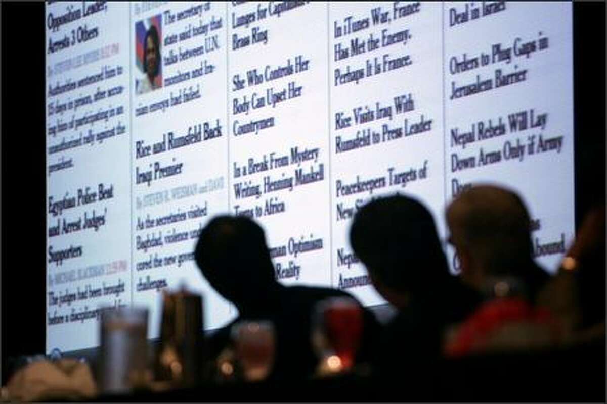 Participants at a newspaper editors convention Friday look at an enlarged version of a computer screen displaying an edition of The New York Times.
