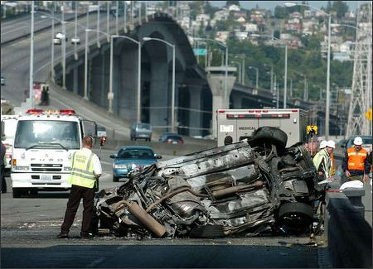 A car traveling eastbound over the West Seattle Bridge early Thursday struck the median at the First Avenue offramp, flipped and burst into flames. Three were killed.