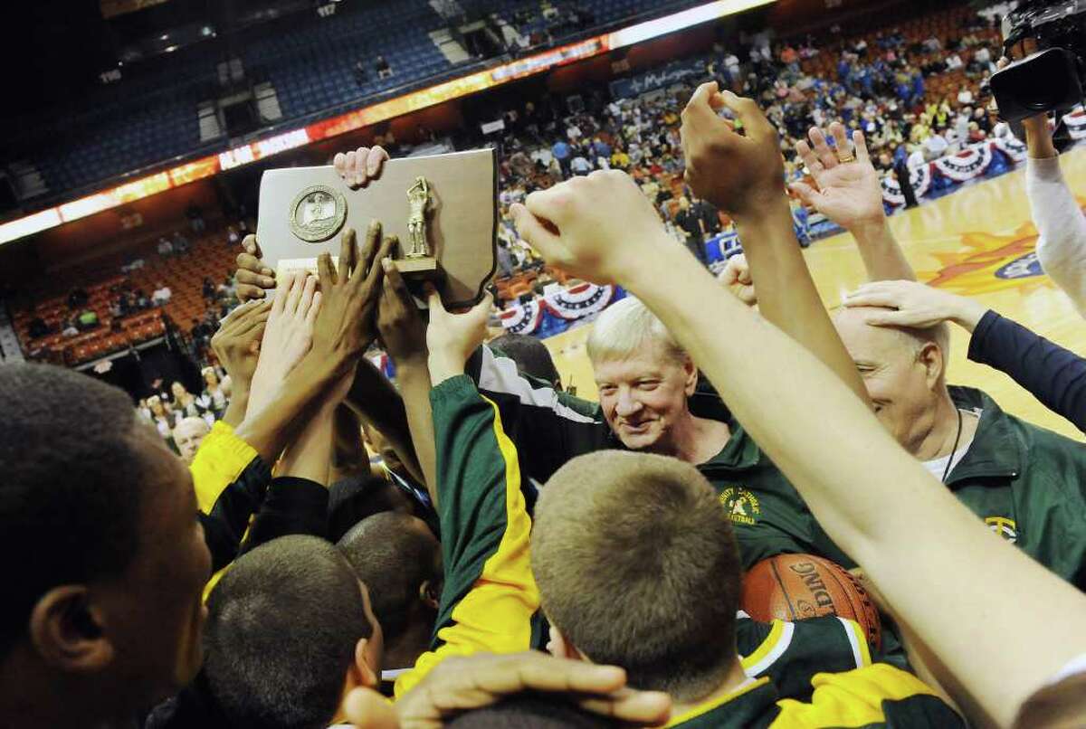 Coach Mike Walsh and the Trinity Catholic boys basketball team celebrate their 57-51 win over Career Magnet in the Class M state championship game at Mohegan Sun Arena in Uncasville, Conn., March 19, 2011.