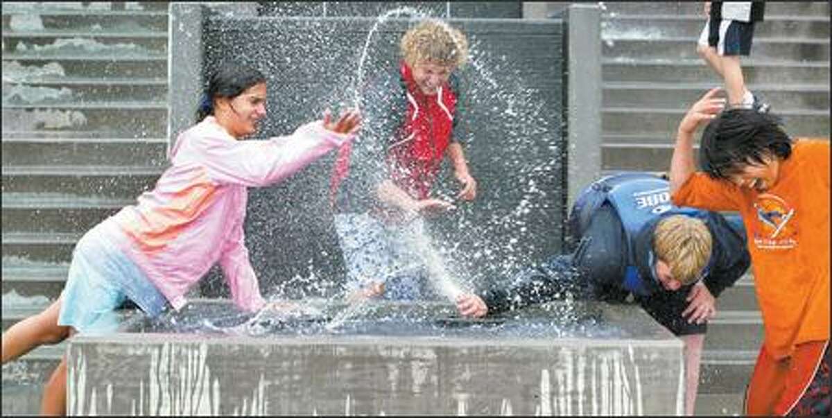 Liana Merrill, Tyler Campbell, Jeff Sargent and Jonathan Ryan have fun with the new fountains installed on Bremerton's redeveloped waterfront. The teens are in a sailing class at the Bremerton Yacht Club and sailed to downtown Bremerton's new marina for lunch. They were already wet from the rainy sail.