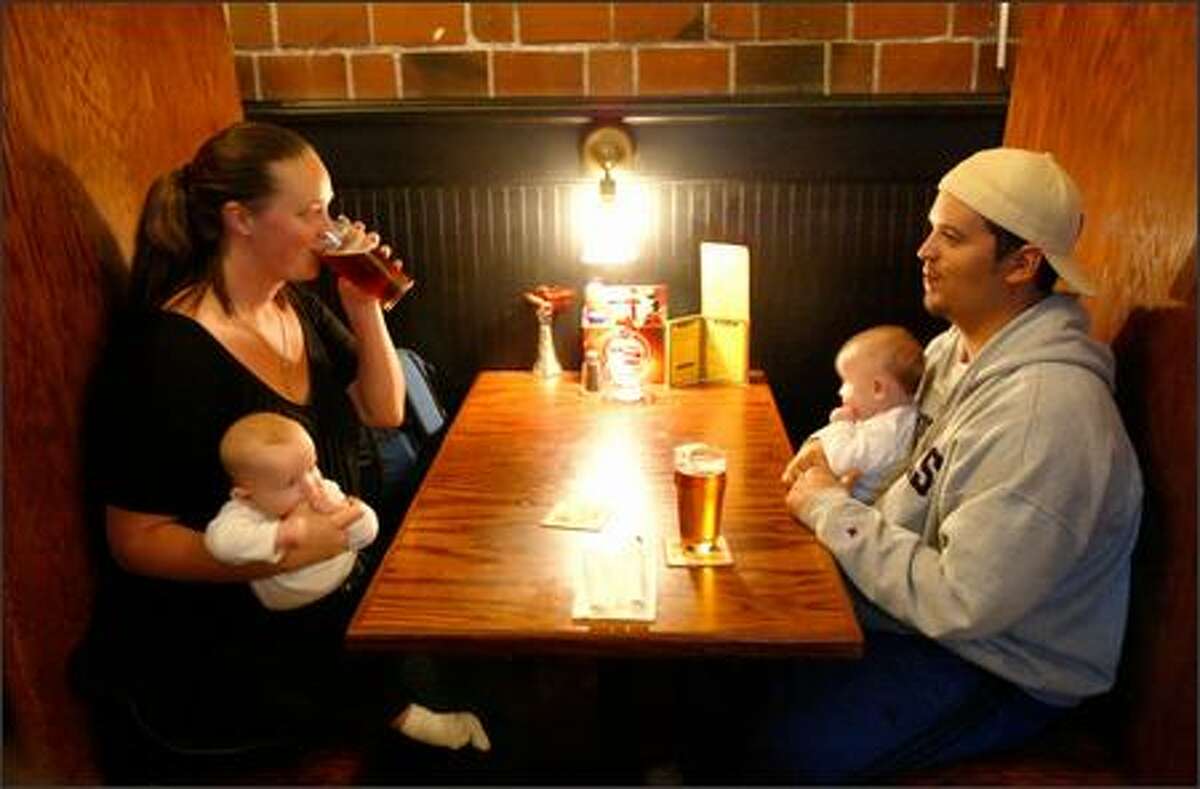Oceania and Chaz Welsh enjoy a pair of pints and quality time with their twins, 4-month-old Nicolai, left, and Carlo, at the Elliott Bay Brewery Pub in West Seattle.