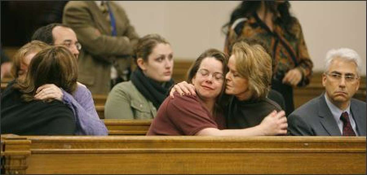 Ianthall Sidell, center right, former board member of the Jewish Federation of Greater Seattle, comforts Carol Goldman, center, one of six victims from last summer's shooting, during Wednesday's hearing. At left, victim Cheryl Stumbo is hugged by Robin Boehler, chairwoman. On the far right is Executive Director Richard Fruchter.
