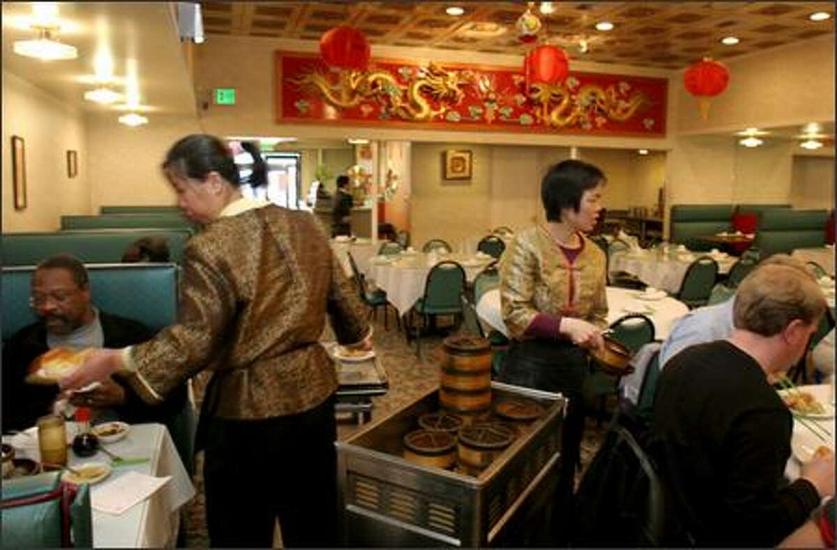 Rui Jin Jiang, left, and Lao Cui Yue serve dim sun at China Gate Restaurant in the International District. China Gate will be one of several Chinese restaurants that will be open for dinner on Christmas.