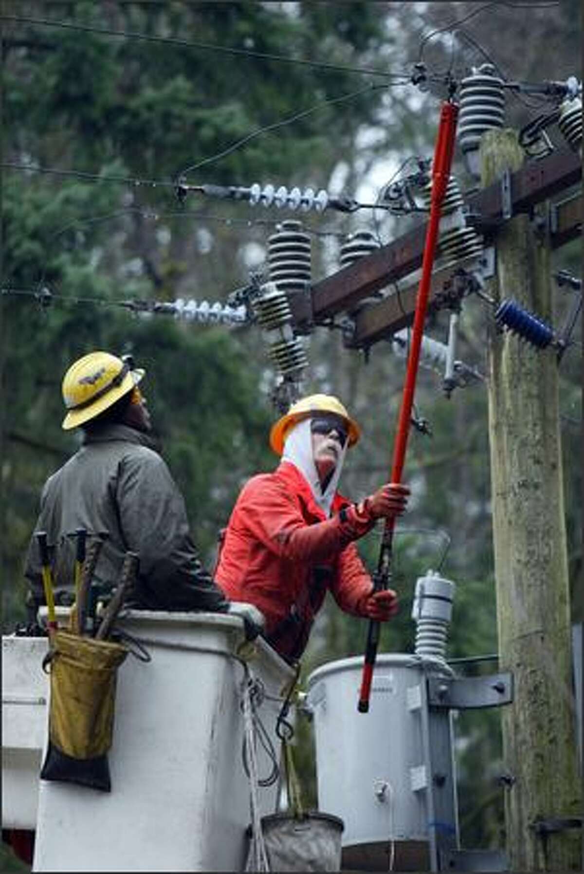 Seattle City Light workers work to replace a transformer bank in Lake Forest Park last week. During the storm response, City Light instituted a rule that limited crews to a 17-hour shift.
