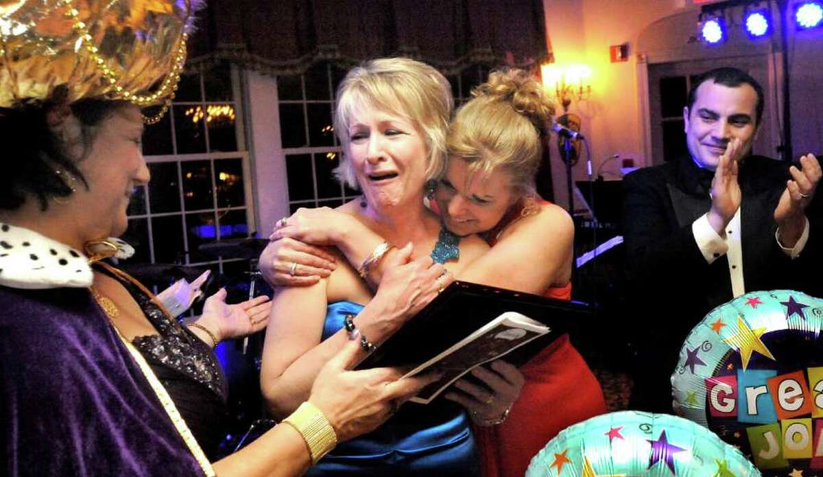 Susan Hallman, center, reacts to being named "member of the year" by Linda Wagner, left, and hugged by Michele Varno, right center, during the Mardi Gras Gala, hosted by the Brookfield Chamber of Commerce. The event was held at The Fox Hill Inn in Brookfield, Saturday, March 19, 2011.