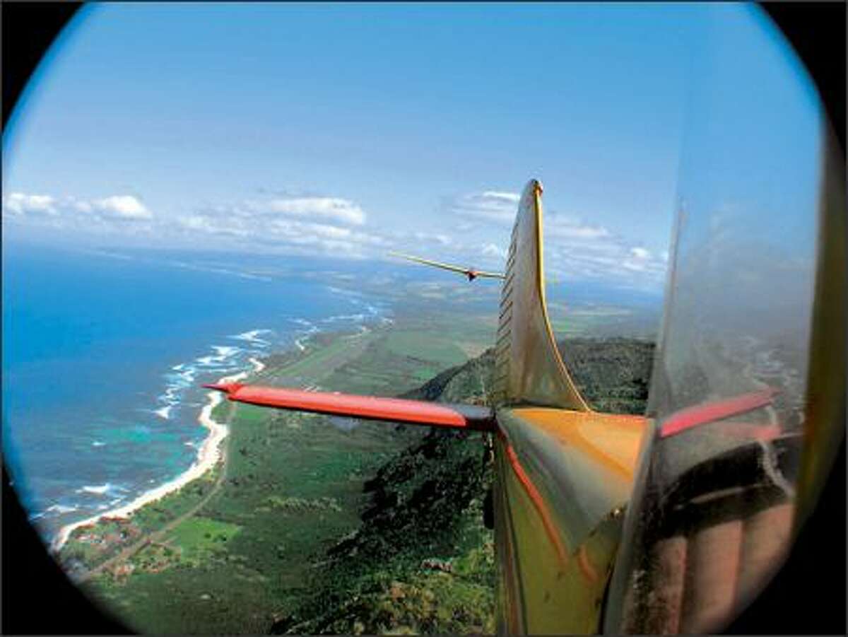 A tow plane pulls a glider aloft over the Oahu coast. After release, the glider generally will cover a radius of five to six miles during its 20-minute flight. The aircraft can carry up to two passengers.