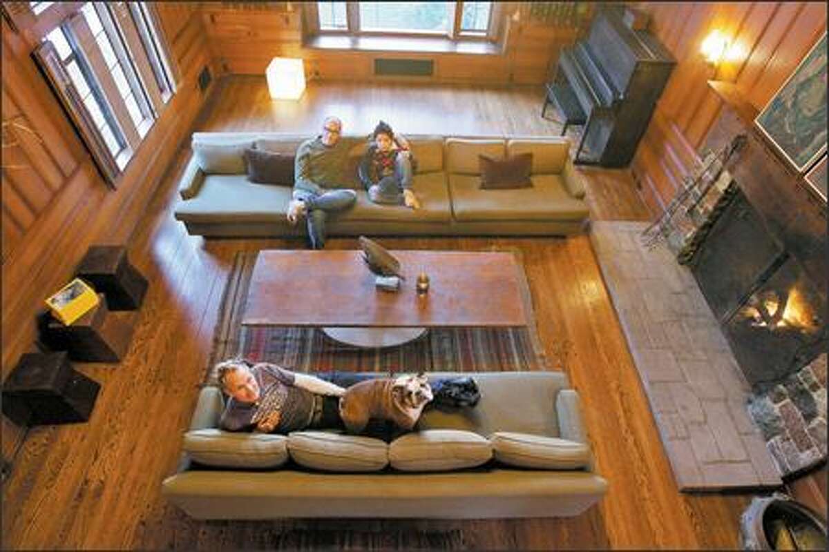 Wade Weigel, top, with son Jason and Jeff Ofelt, relax in the great room of their historic, 1933 home in the northwest Seattle neighborhood of North Beach. They were initially intimidated, but bought it last month.