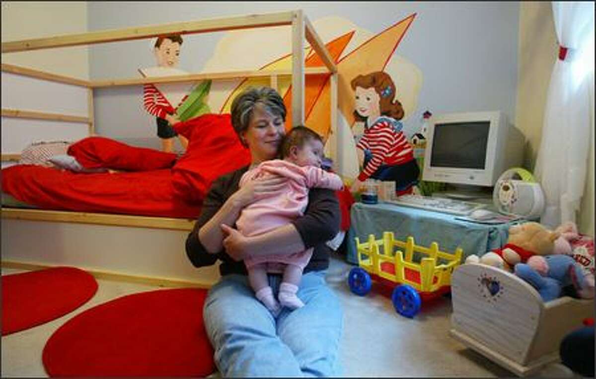 Andrea Riseden-Perry cradles 3-month-old daughter Genoa in older daughter Aspen's bedroom. Though she knows her breast milk contains PBDEs, Riseden-Perry continues to nurse Genoa because it is the best food for babies.
