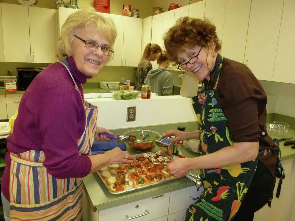 Sandy Molden of Black Rock and Samantha Heilweil of Fairfield collaborate to make double tomato bruschetta at "Feeding the Mixed Table" program staged in conjunction with the One Book, One Town program.