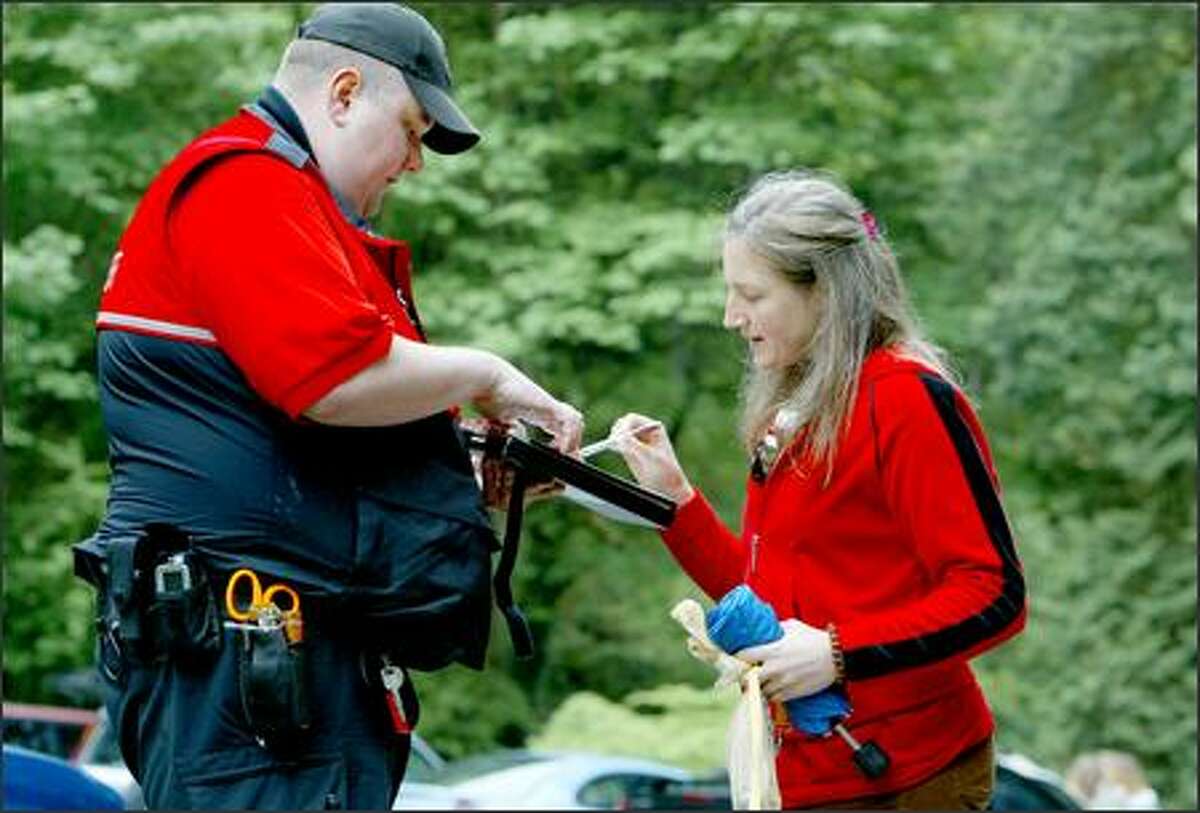 Laura Ellis of Edmonds gets a ticket from Neil Deruyter, a Seattle animal control officer, after leaving the Golden Garden's off-leash area without her dog on a leash.