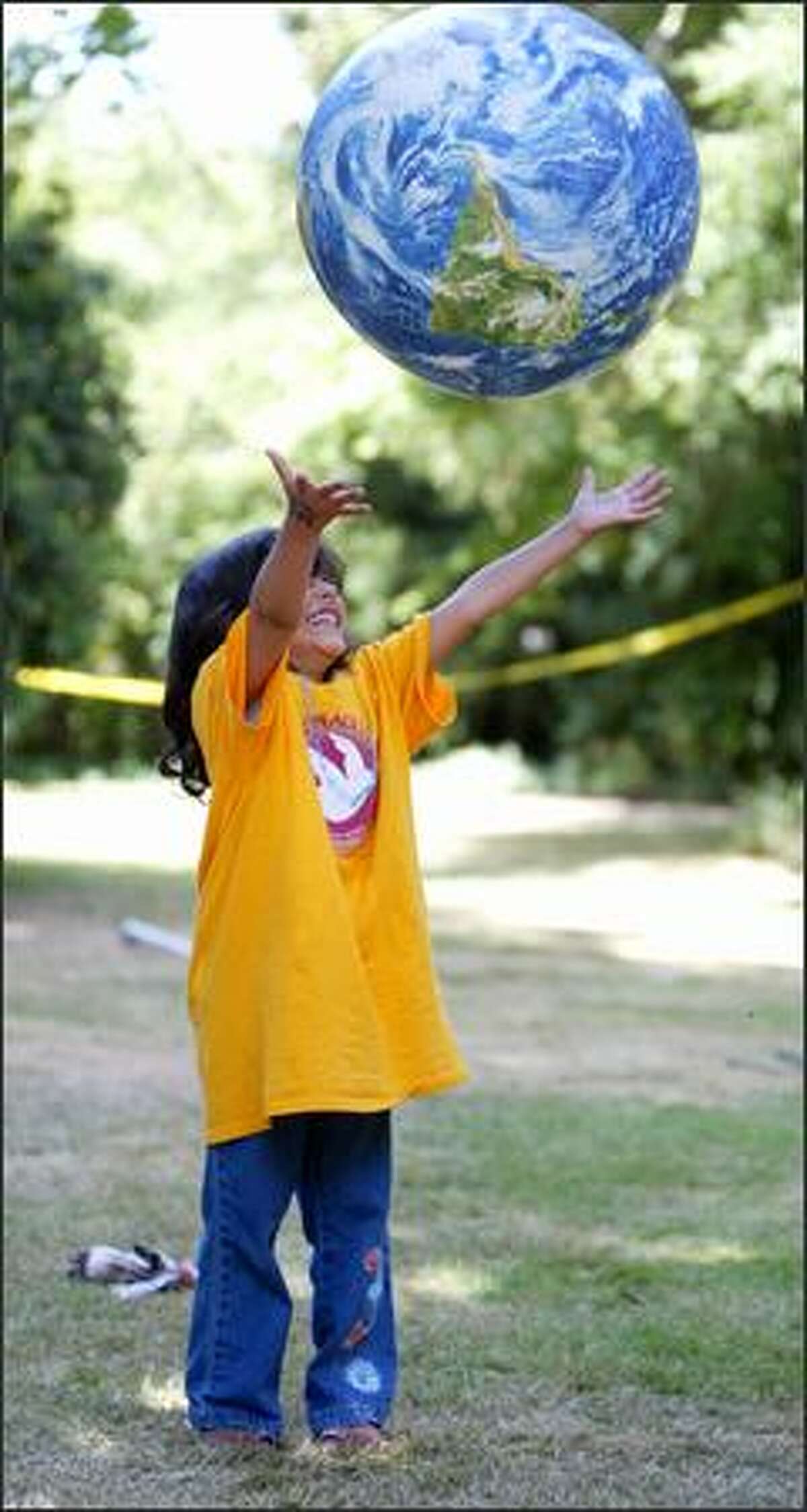 Aliyah Alothaimeen, 5, catches an inflatable globe during Middle East Peace Camp at the home of local peace activist and philanthropist Kay Bullitt on Wednesday,