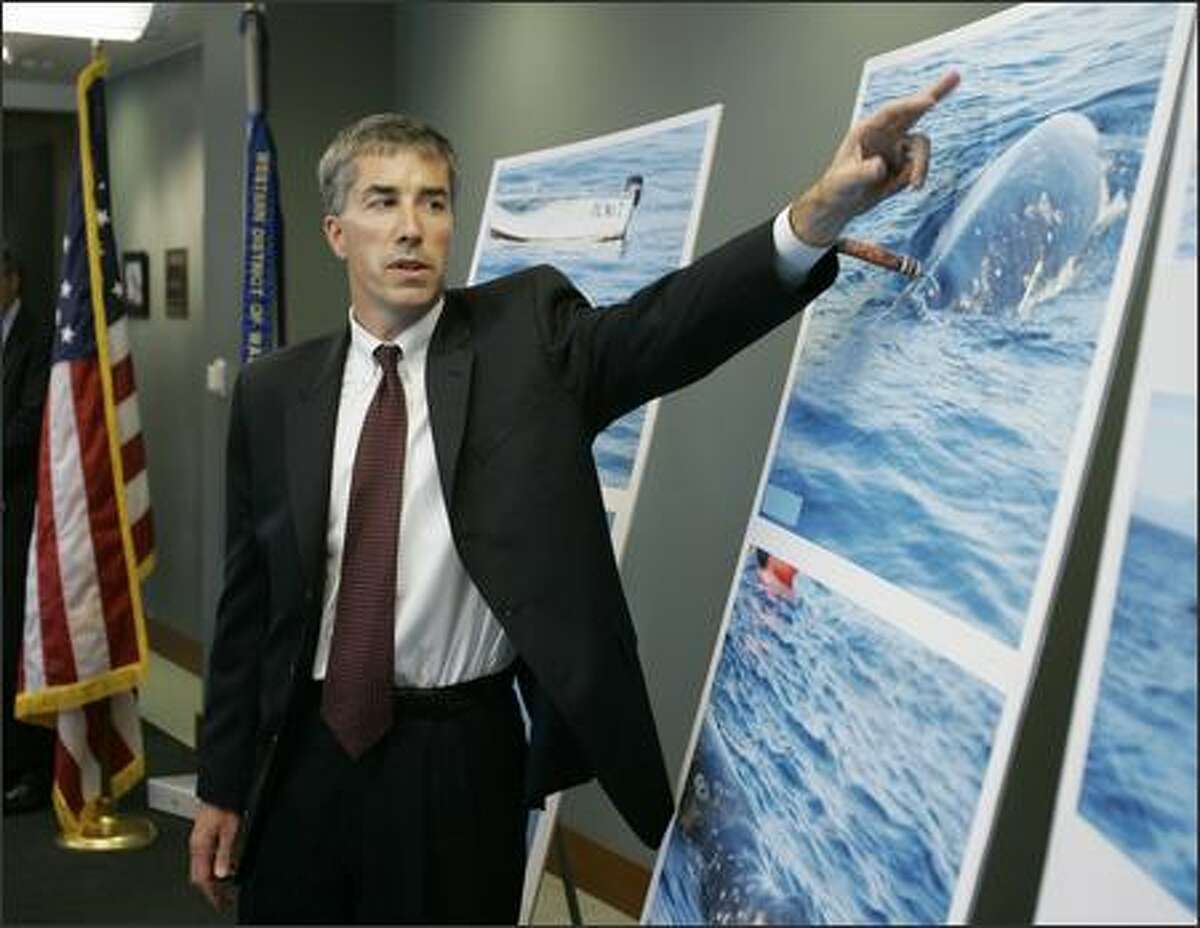 Assistant U.S. Attorney Jim Oesterle points to photos of a harpooned gray whale at the federal courthouse Thursday in Seattle.