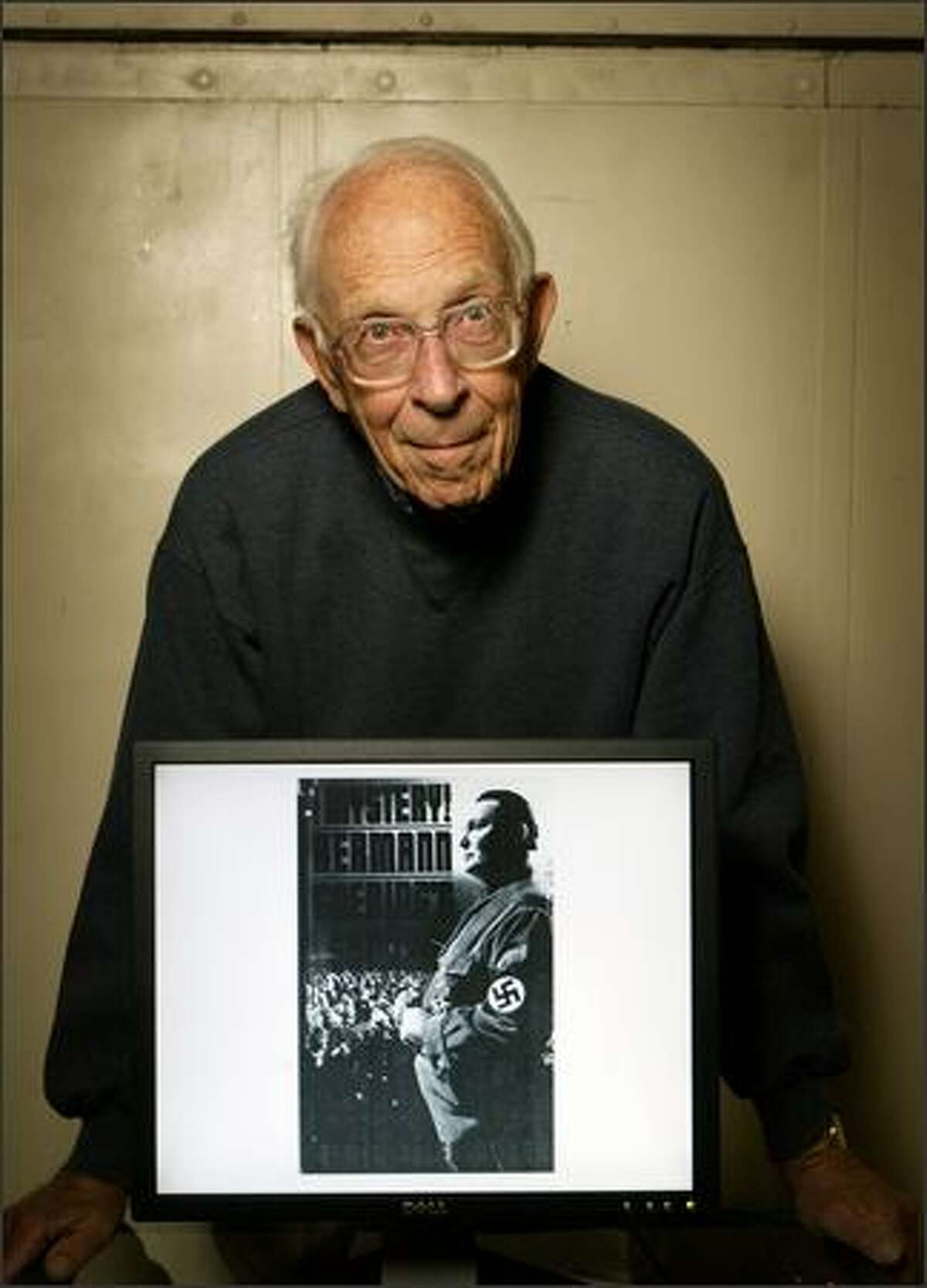 Jack Carver holds a portrait of top-ranking Nazi Hermann Goering, whom he met while a prison guard during the Nuremberg trials in Germany after World War II. The prison was attached to the courthouse.