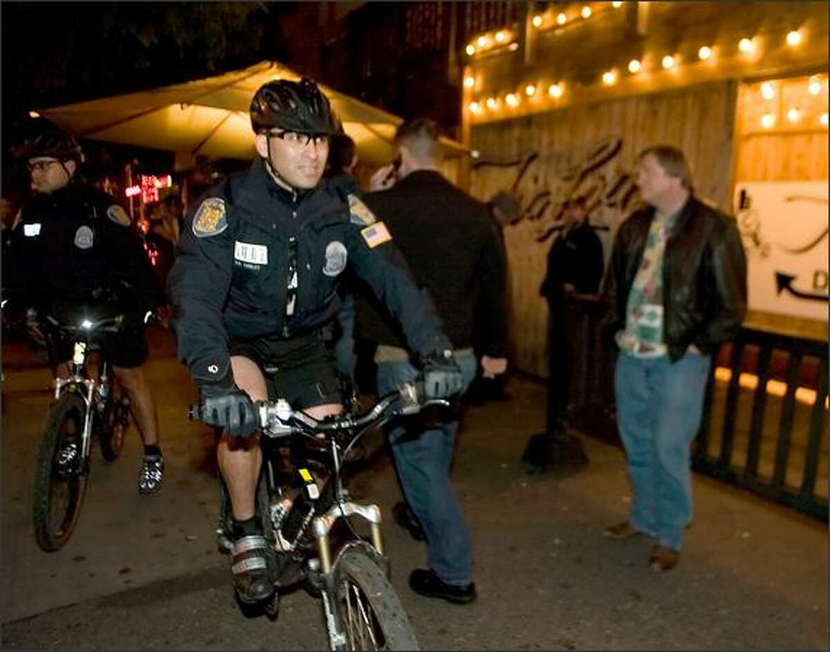 Seattle Police Officers Rob Cierley, left, and Raul Vaca cruise the Belltown bar scene. Other cities have modeled Seattle's program.
