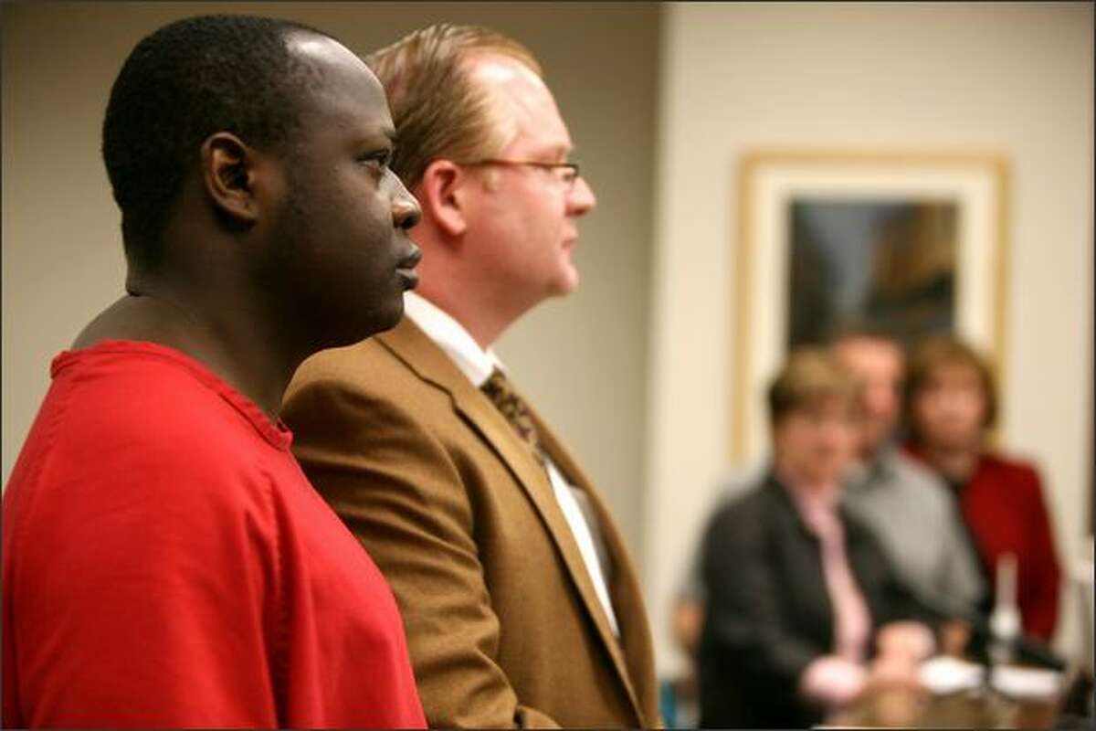 Lamin Darboe and his attorney, Gene Piculell, listen Friday in King County Superior Court to a statement from relatives of the woman Darboe was convicted of raping.